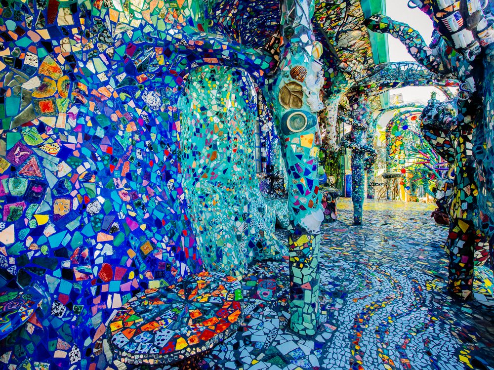 Colorful tile mosaic covers walls, columns, floor, and tables in an outdoor decorative art installation, CA, USA.