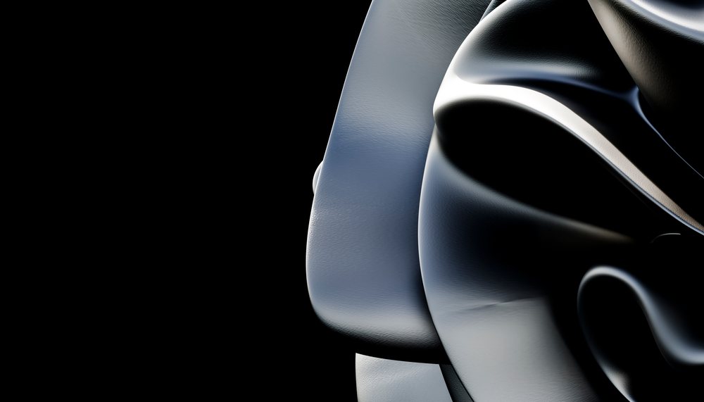 Abstract close-up of a sleek, glossy, black curved surface with smooth texture and sharp highlights.