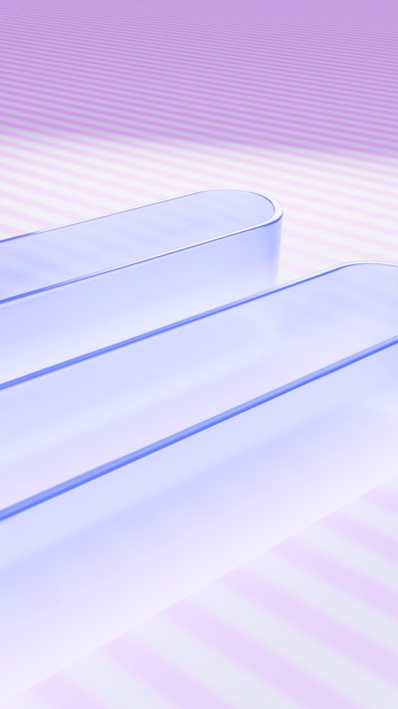Three transparent glass tubes with smooth curved edges placed parallel on a purple striped surface in a minimalist abstract composition.