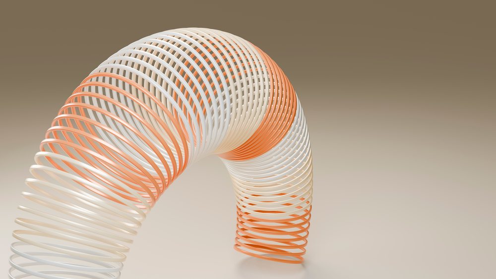 Flexible curved orange and white helical coil isolated in a gradient studio setting.