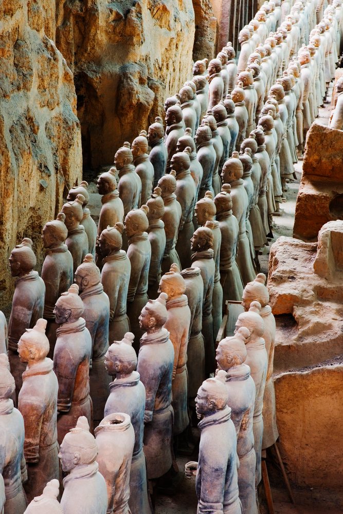 Rows of ancient terracotta warrior statues made of clay lined up at an excavation site, Shaanxi Province, China.