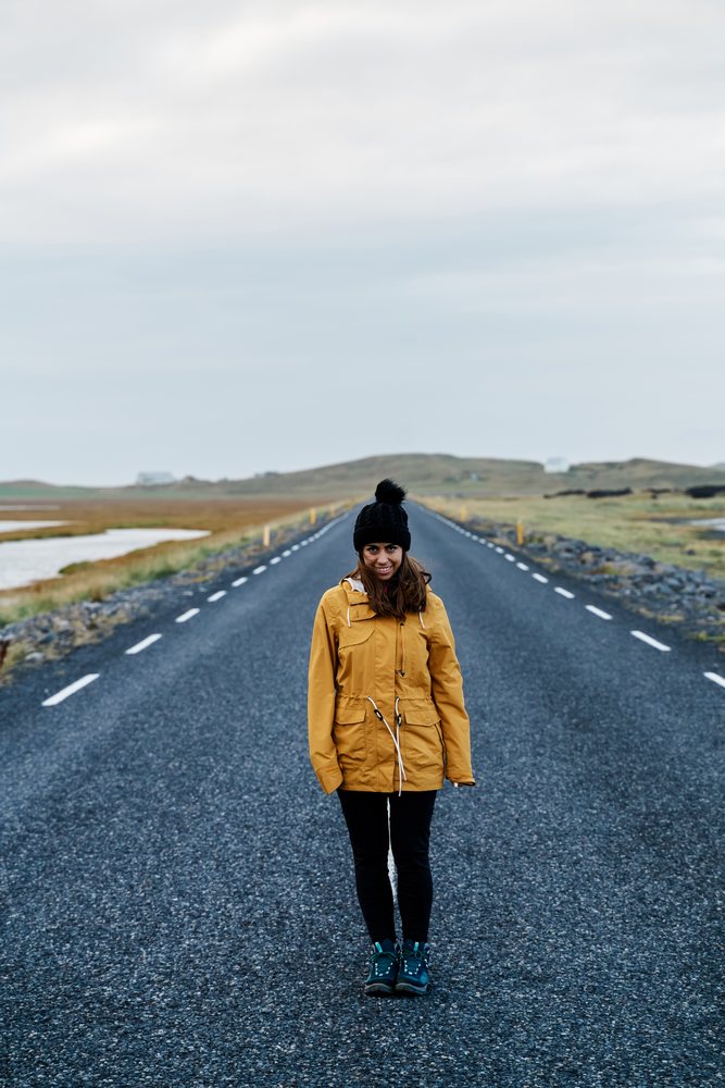 A white woman stands on a rural road