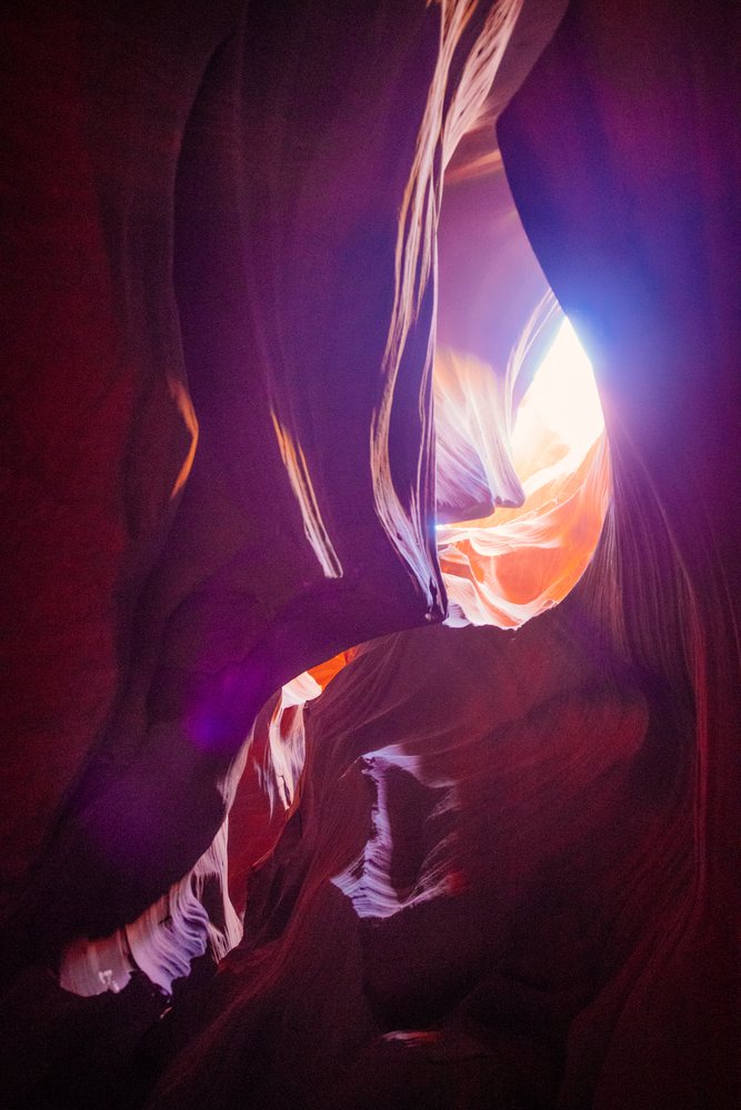 Natural light illuminates smooth red sandstone rock formations in Antelope Canyon slot canyon located, Navajo Land, Arizona, USA.