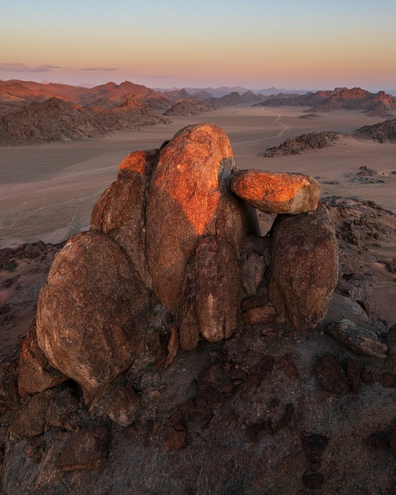Balanced Rock formation illuminated by orange sunlight at sunset in the arid desert landscape of, Stone Valley, Kunene Region, Namibia.