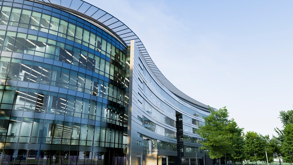 Modern office building with curved glass facade.