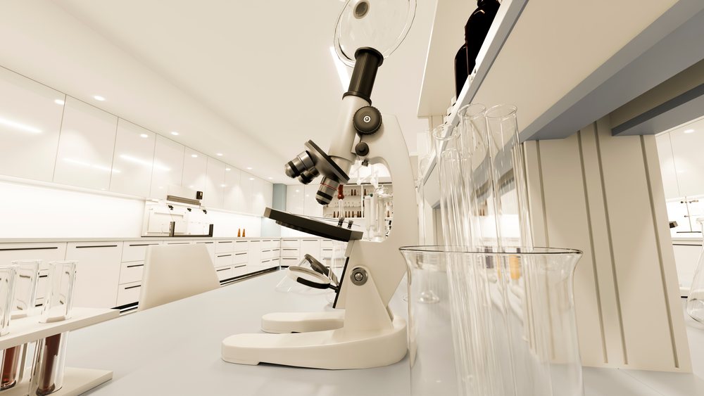 Microscope and test tubes on a lab bench inside a modern scientific research laboratory environment.