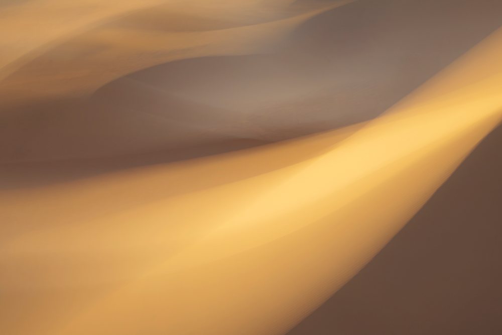 Sunlit sand dunes with shadows form abstract patterns in the dry Erg Lehoudi desert, Lifestyle, Landscape, Culture, M'hamid, Zagora Province, Morocco.