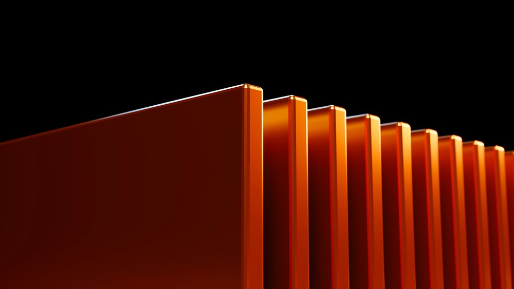 Close-up of orange rectangular metal panels with smooth surfaces aligned against a black background.