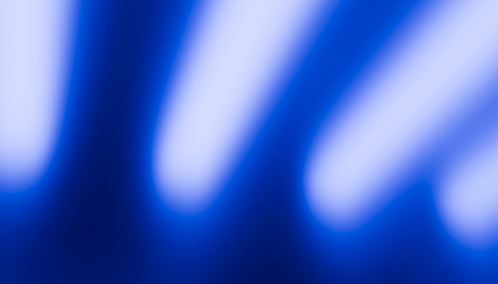 Abstract blue blurred light streaks creating a soft glowing effect with smooth gradients.