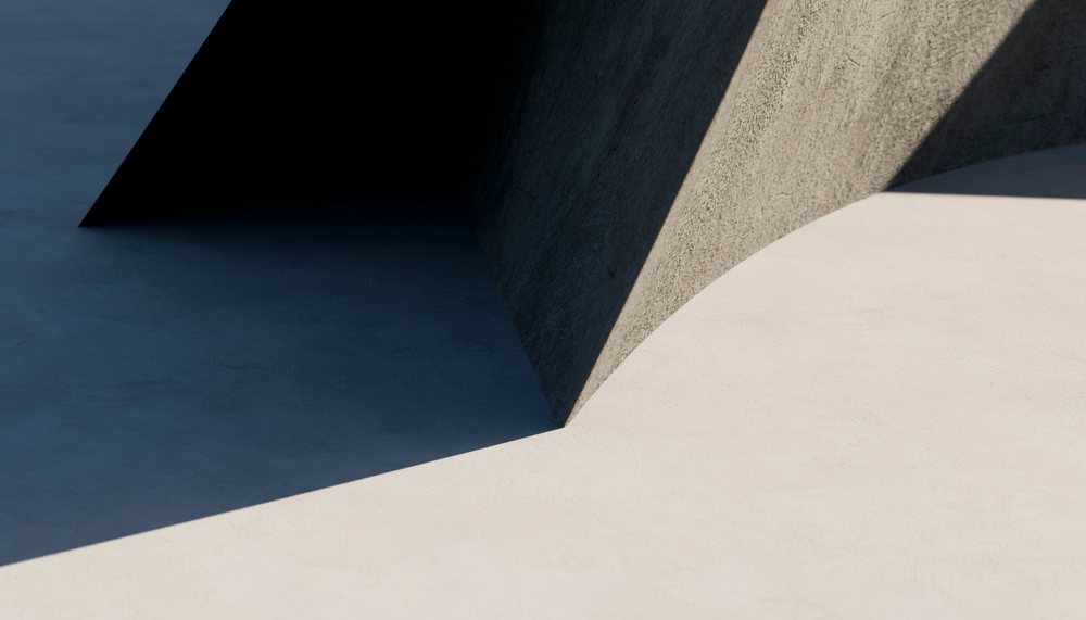 Minimalist concrete structure casting sharp shadows on outdoor surface
