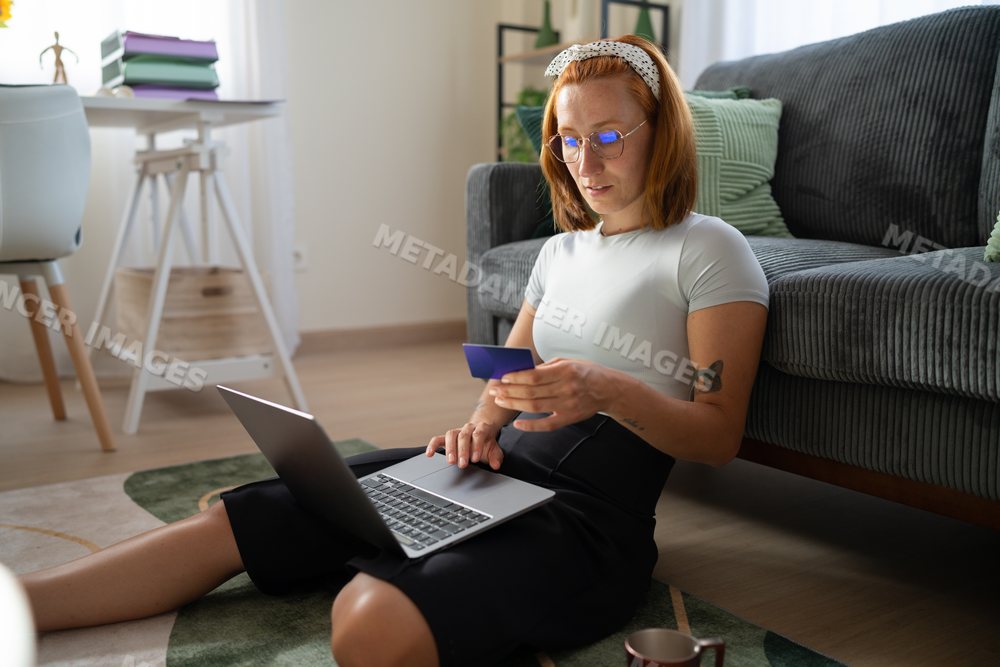 A white woman shopping online with a credit card