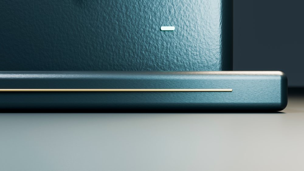 Close-up of a modern blue speaker with textured surface and golden strip decoration on a neutral background.