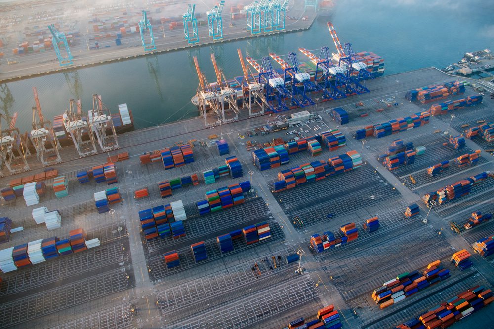 Aerial view of shipping containers arranged at a cargo terminal with container cranes at the port in Long Beach, port in Long Beach, CA, USA.