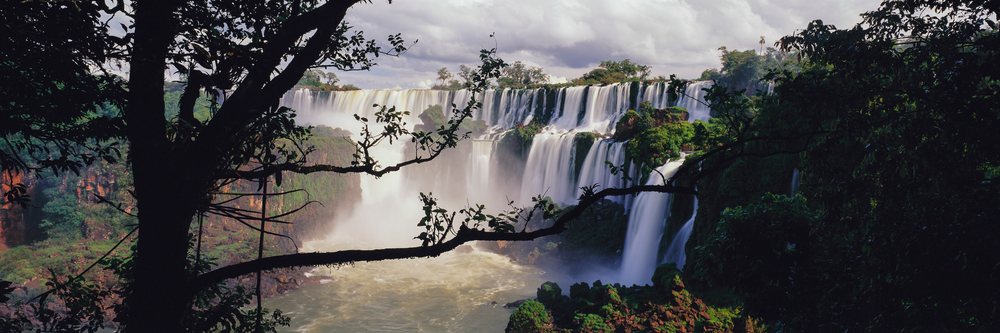 Iguacu Falls cascade amid dense tropical rainforest with rock formations and mist in Misiones, Iguacu Falls Misiones, Argentina.