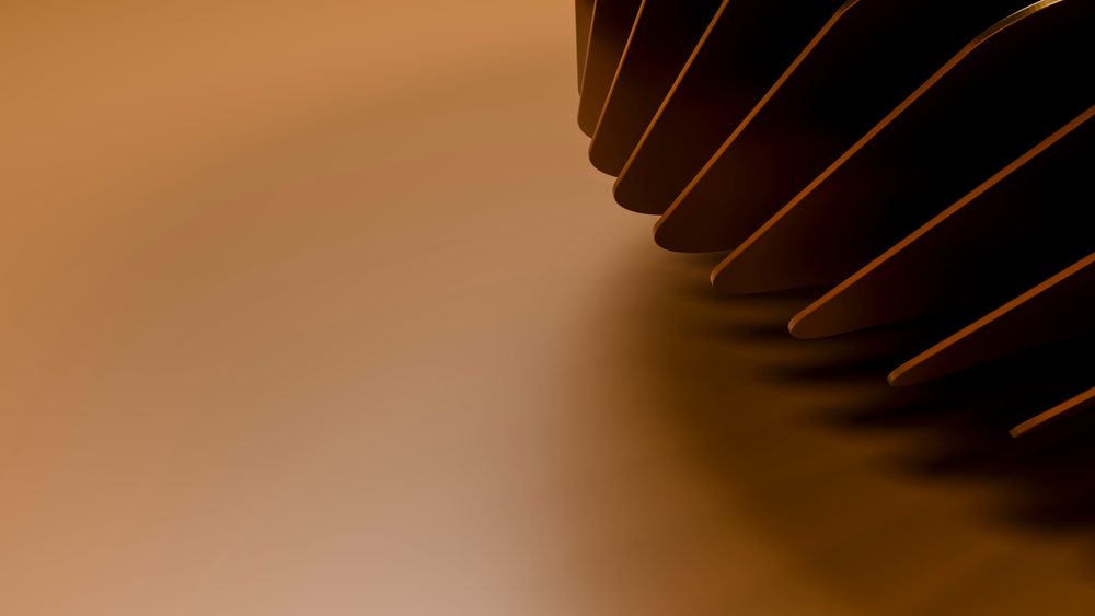 Close-up of metal gear teeth casting shadows on a brown industrial surface.