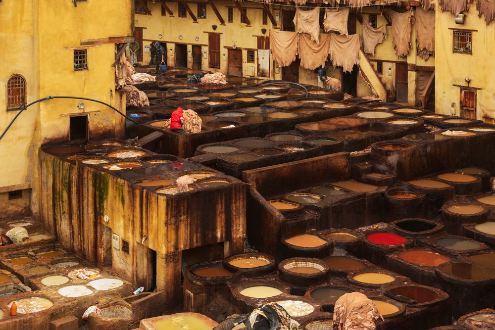 Workers process leather hides in dyeing vats at the Chouara tannery during Pouring Rain, Landscape, Lifestyle, Fes, Fes-Mekners Administrative Regio, Morocco.
