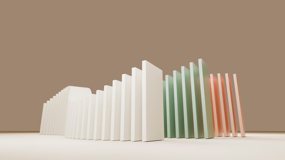 Illustration of white, green, and peach domino tiles arranged standing upright in sequence on a smooth neutral background.