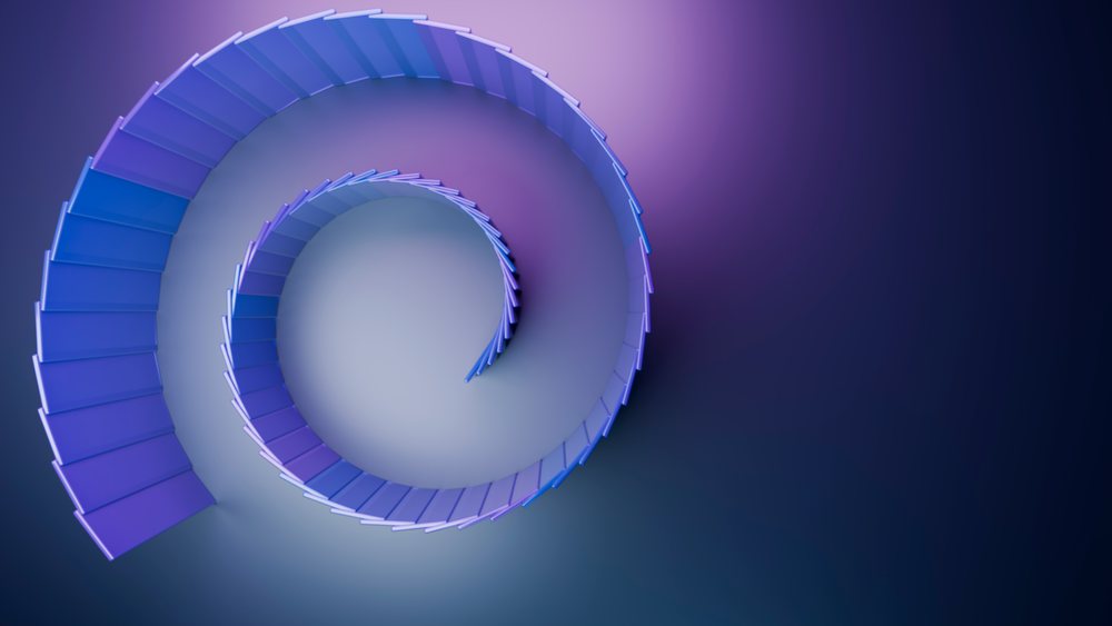 Top view of a modern curved spiral staircase with blue and purple gradient steps and a handrail in a minimalist interior.