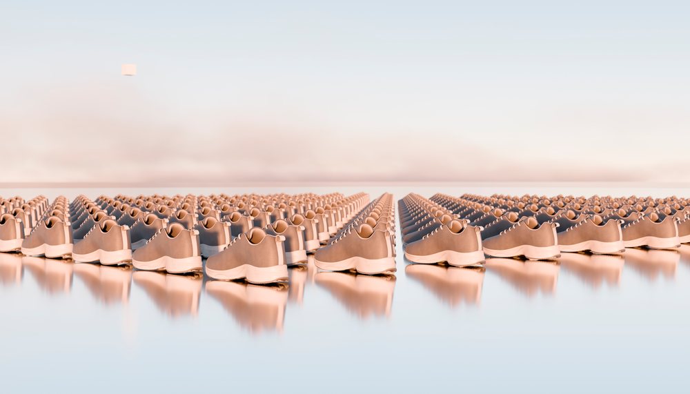 Rows of brown shoes with white soles arranged in a precise pattern on a reflective surface with a minimalist background.