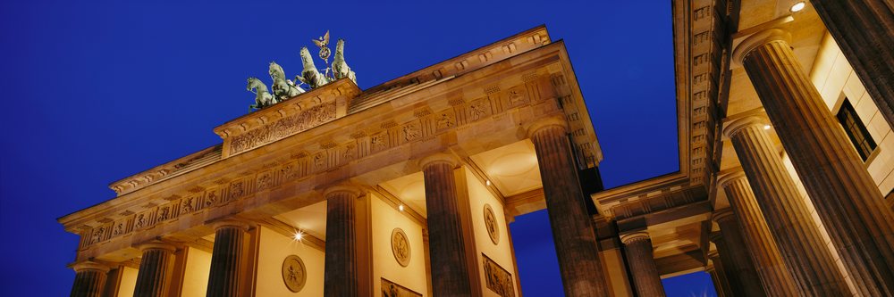 Brandenburg Gate illuminated at night, showcasing its neoclassical columns and iconic quadriga sculpture, Germany.