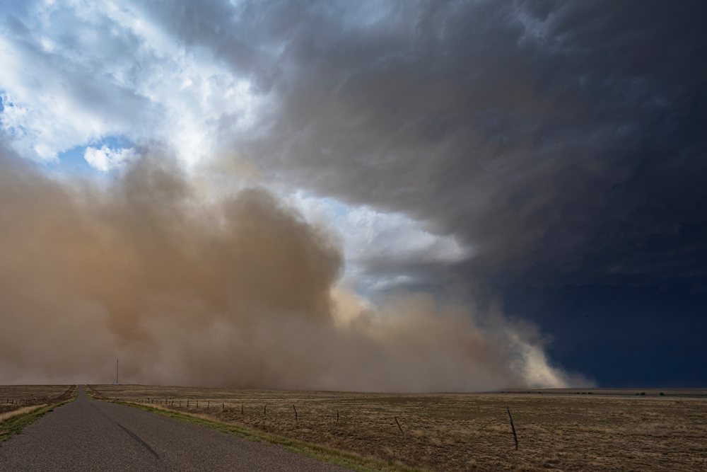 Approaching Haboob Dust Storm advancing over dry terrain along County Road 2, under a stormy sky, Storm Chasing, Weather, Environment, Fowler, Colorado, USA.