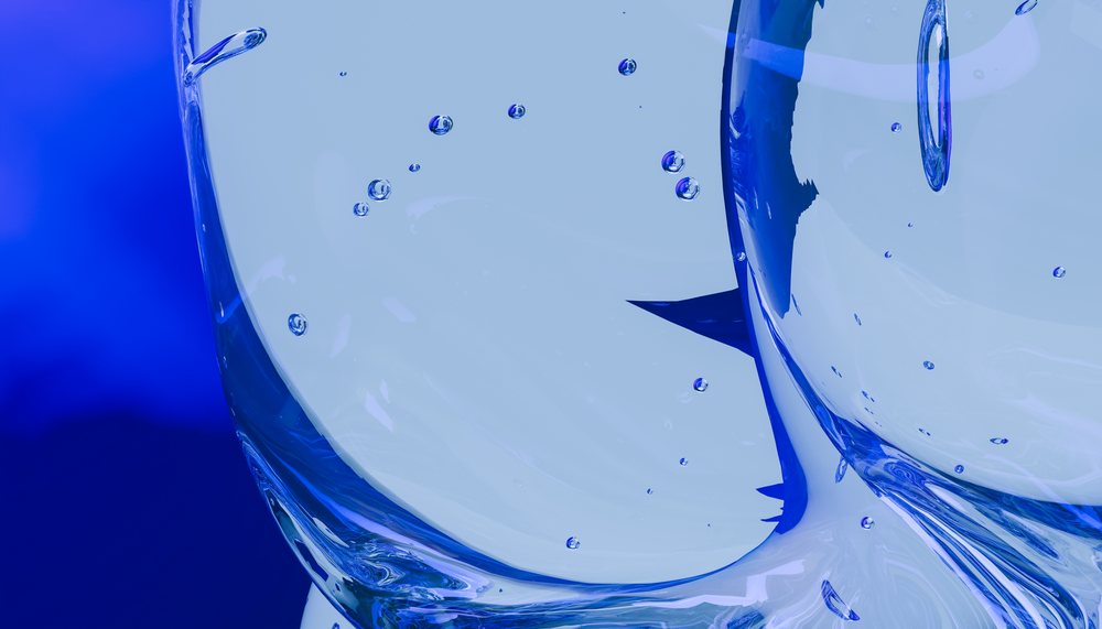 Abstract blue liquid with air bubbles inside a transparent glass surface, creating fluid and reflective textures.