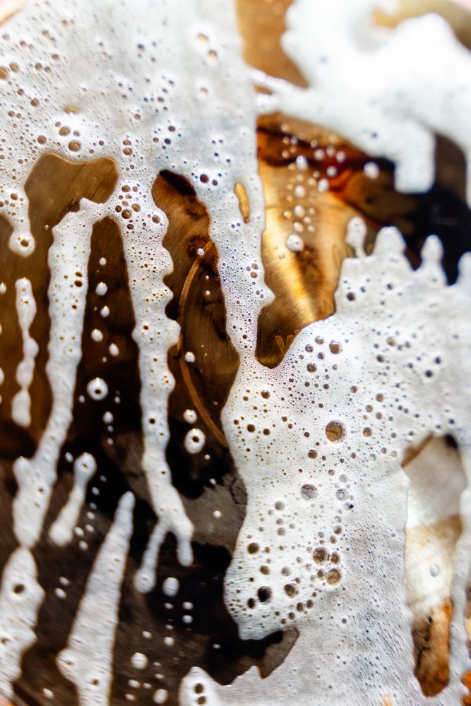 Close-up showing foam bubbles forming an abstract wet texture pattern on a brown surface, abstract texture, background, wallpaper, Spain.