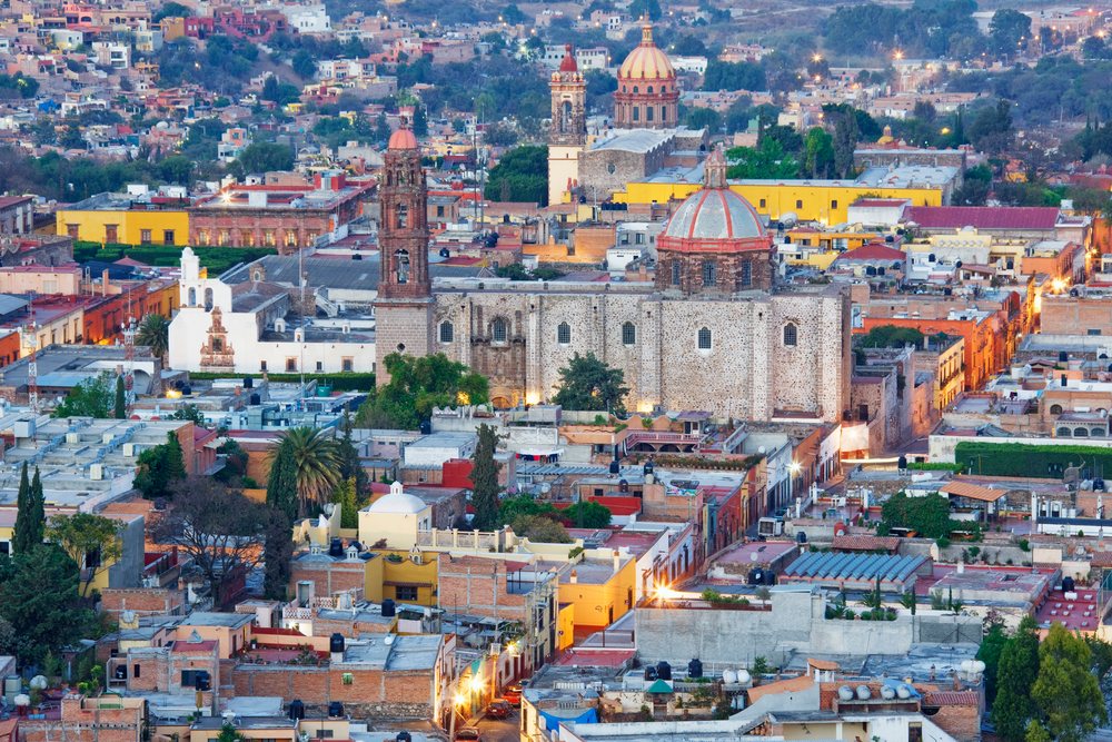 Cityscape of San Miguel de Allende with historic churches and colorful colonial buildings at twilight, Guanajuato, Mexico.