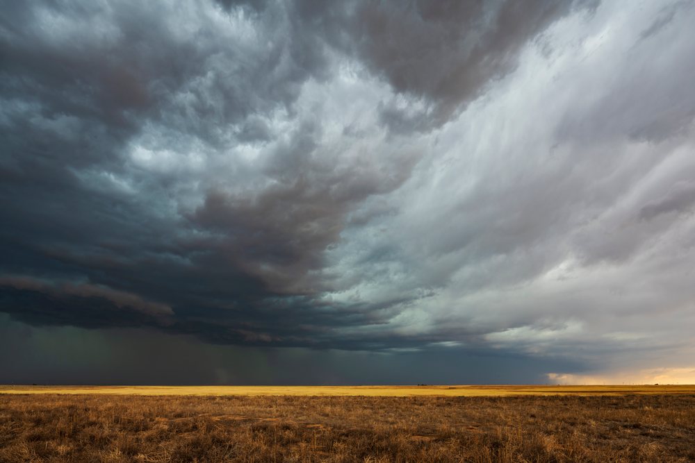 Storm Cell with dark, dense clouds over a dry grassy field in Tornado Alley on the Great Plains, Storm Chasing, Weather, Environment, Dumas, Texas, USA.
