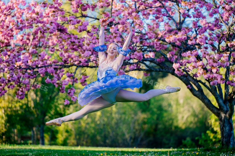 A ballerina leaps gracefully outdoors