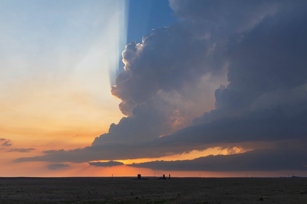 Storm cloud with crepuscular rays is visible at Sunset over flat plains, Storm Chasing, Weather, Environment, Grover, Colorado, USA.