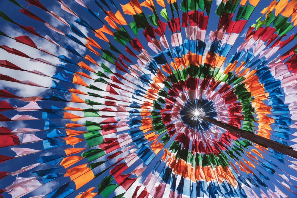 Colorful fabric prayer flags form a concentric circular tented structure around a central pole under a blue sky, Shiqu, Sichuan Province, People's Republic of China.