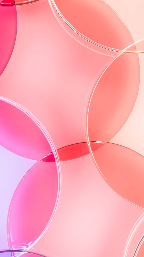 Abstract overlapping transparent circles in pink, red, and purple with smooth curves and reflective surfaces.
