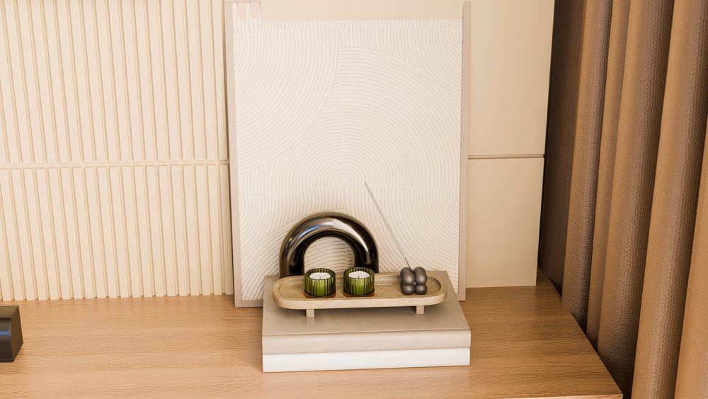 Decorative display with two green candles and metallic incense holder on a small tray resting on stacked books indoors.