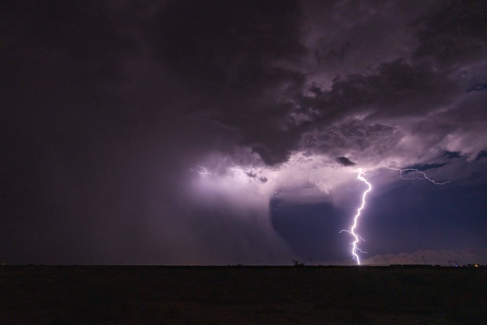 Lightning bolt strikes from a Thunderstorm over a dark night sky, Storm Chasing, Weather, Environmental Issues, McNeal, Arizona, USA.