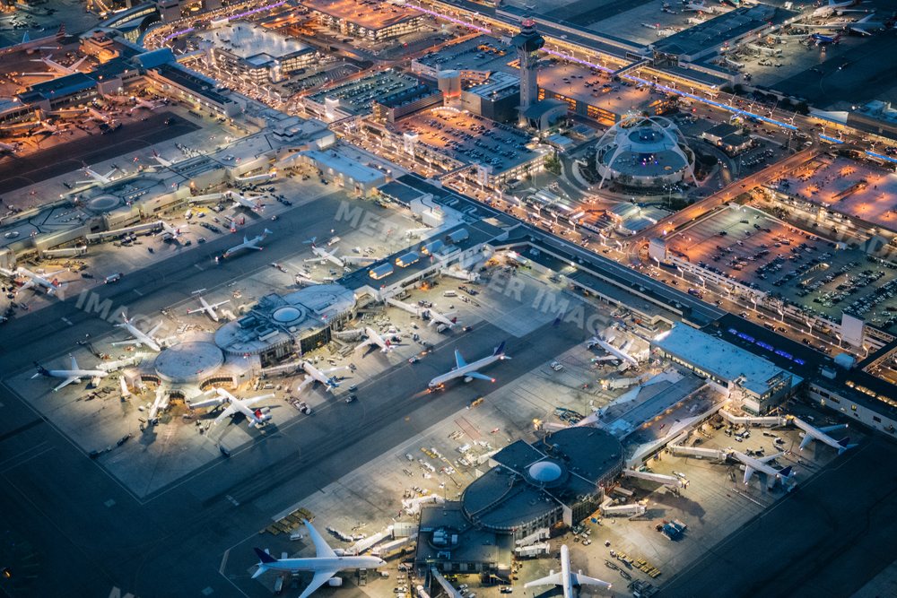 Aerial view of an airport with airplanes and terminal at dusk in Long