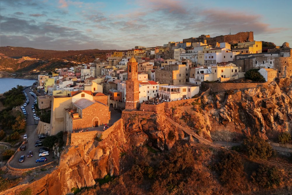 Stone church with bell tower on rocky cliff overlooking Castelsardo coastal village at Sunset, Travel Images, Sardinia, Italy.