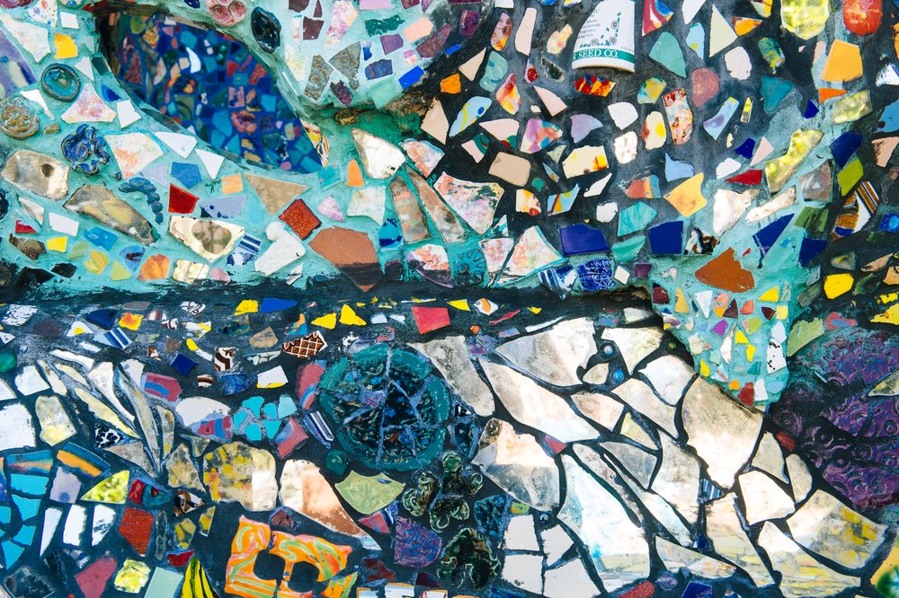Abstract mosaic wall made of colorful broken ceramic tiles separated by grout, CA, USA.
