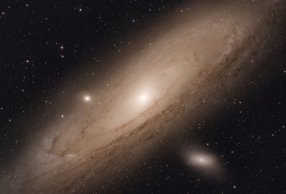 Spiral galaxy with stars and cosmic dust visible in outer space, captured through astrophotography.