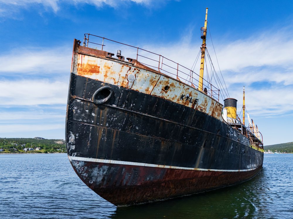 The rusted SS Kyle shipwreck floats in water, Newfoundland and Labrador, under a clear sky, Landscape, Wildlife, Lifestyle, Harbour Grace, Newfoundland & Labrafor, Canada.