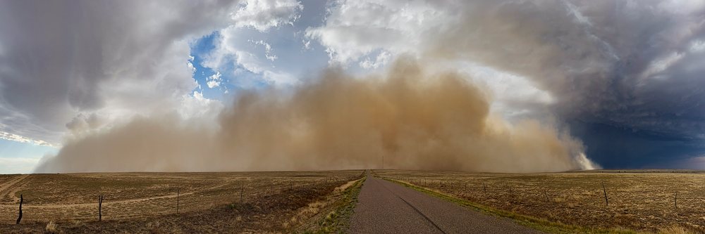 Approaching Haboob Dust Storm approaches over an open field with a road and fence, under thunderstorm clouds, Storm Chasing, Weather, Environment, Fowler, Colorado, USA.