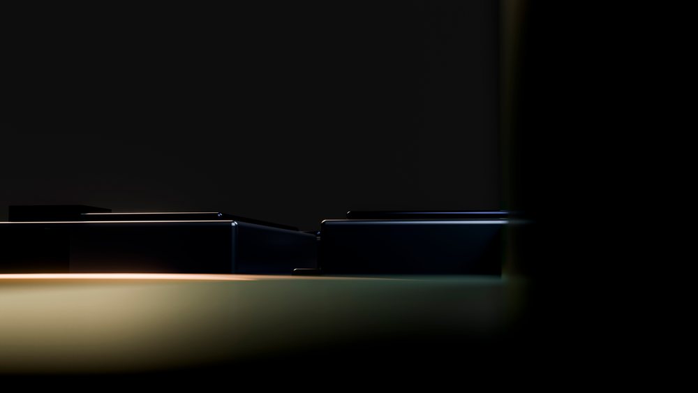 Close-up of black piano keys on a grand piano illuminated against a dark studio background.