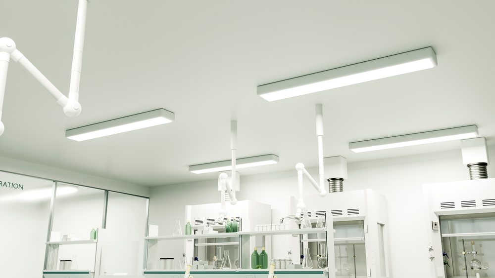 Clean and organized laboratory interior featuring scientific glassware, shelves, ventilation pipes, and fluorescent ceiling lights.