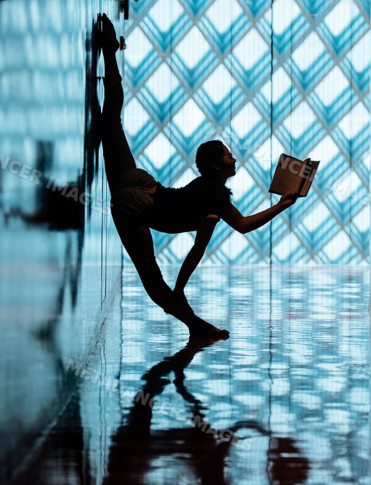 A woman stretches and reads a book