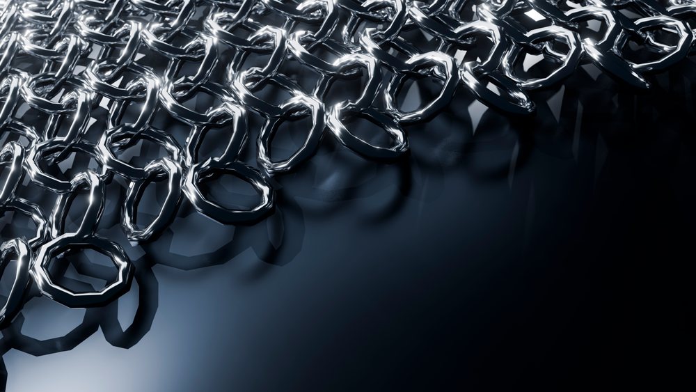 Close-up view of interlocking metal chainmail rings forming a reflective protective armor surface on a dark background.