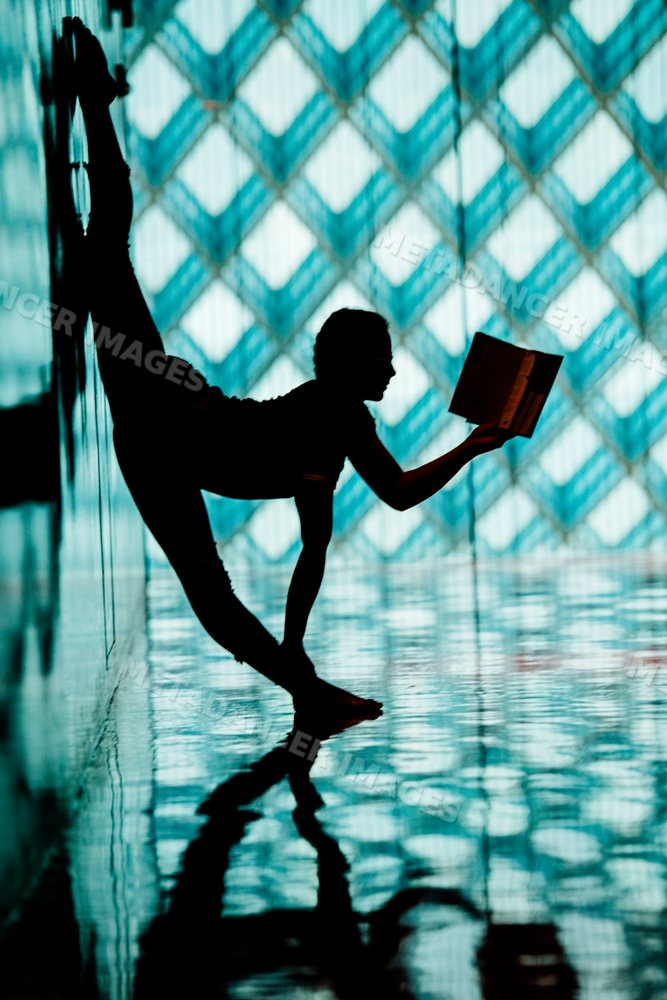 A woman stretching in a yoga pose while reading in a library