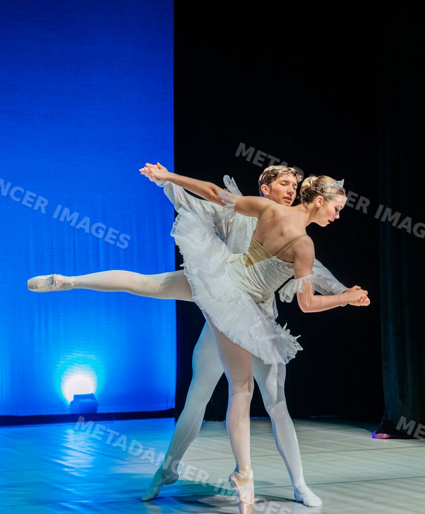 Ballet dancers perform a pas de deux on stage during a dance