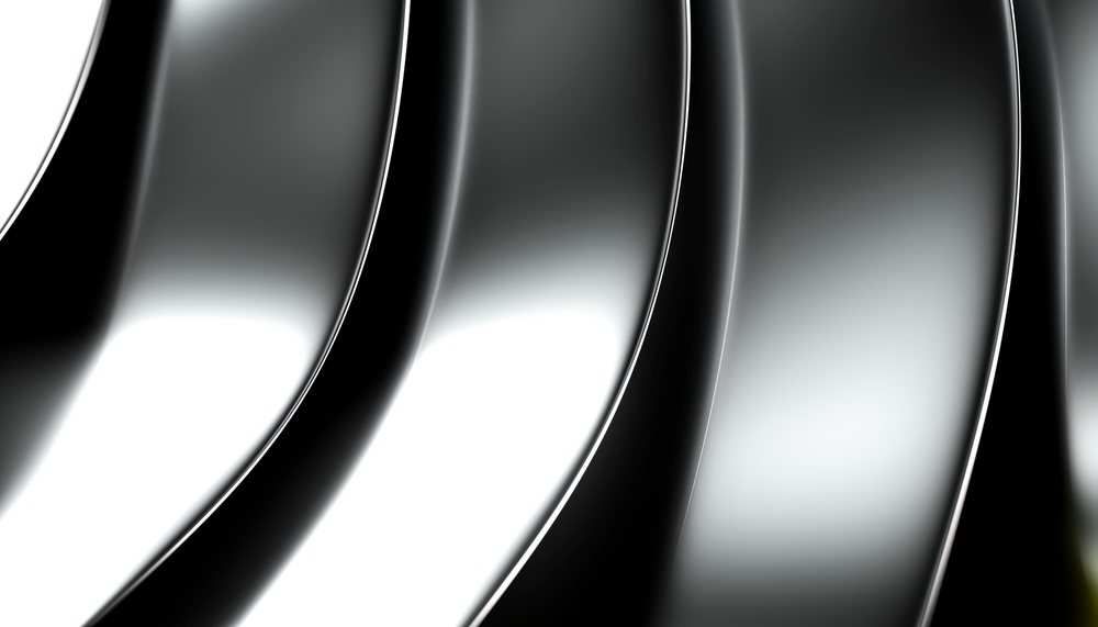 Curved and reflective silver metal surfaces create an abstract pattern with smooth gradients and shine.