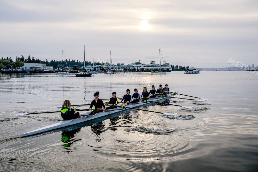 Eight-white person rowing team practicing on calm water in washington