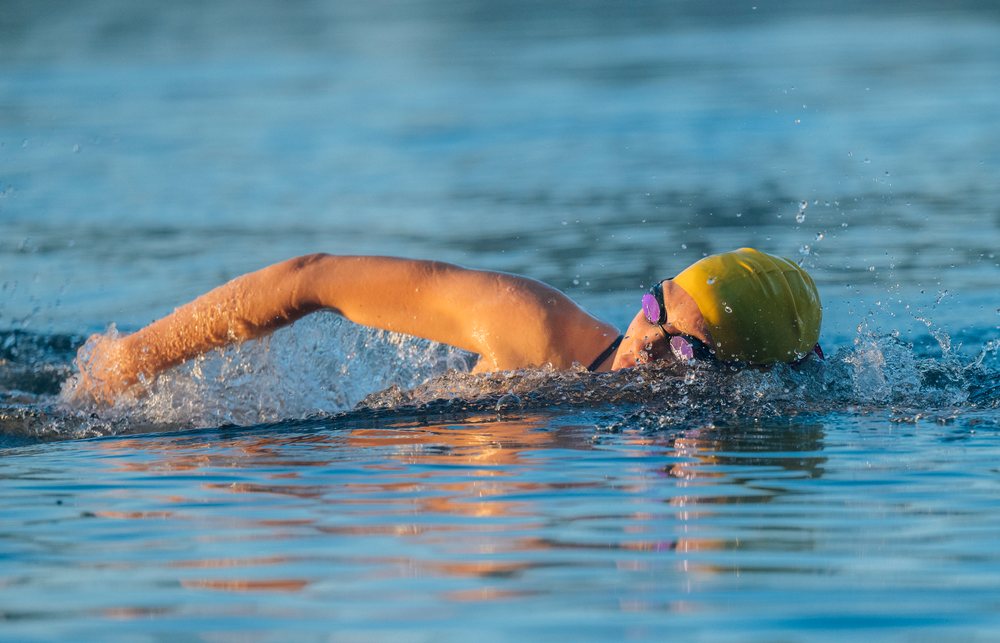 Swimmer performing a freestyle stroke in open water during outdoor training, USA.
